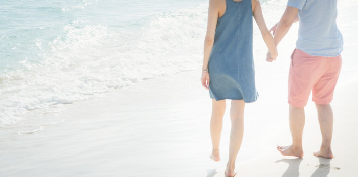 白い浜辺を歩くカップル