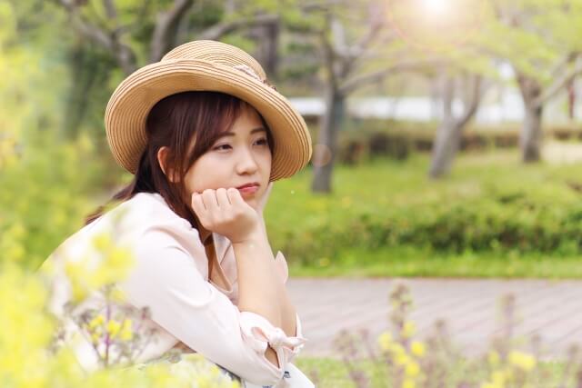 浮かない顔で遠い目をしている女性。